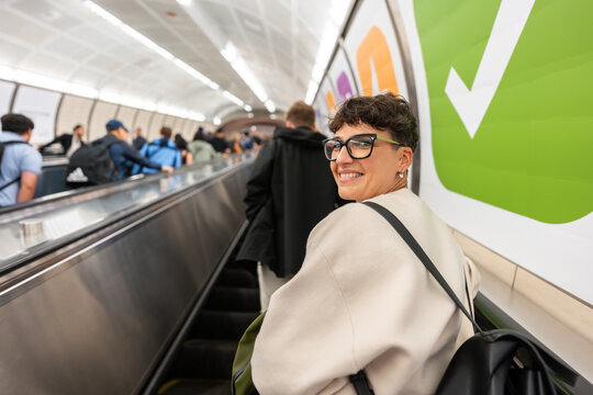 Smiling businesswoman going up on escalator in New York City