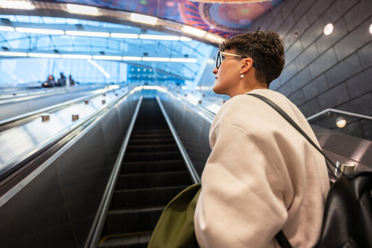 Young woman going up escalator in New York City subway station