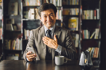 書斎・執務室・社長室にいる中年アジア人男性ビジネスマン（弁護士・役員・教授・法律事務所）
