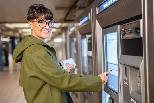 Woman buying subway ticket at ticket machine in New York City