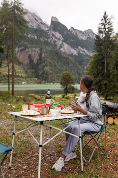 woman eating while camping in the dolomites, italy
