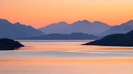 Fototapeta premium Serene sunset over tranquil waters with silhouetted mountains in the distance.
