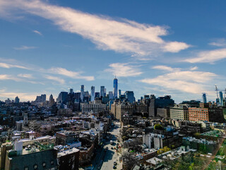 Urban cityscape under a partly cloudy sky.  Numerous buildings and skyscrapers.