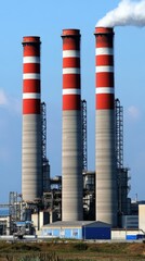 Obraz premium Three Tall Industrial Smokestacks Red White Concrete