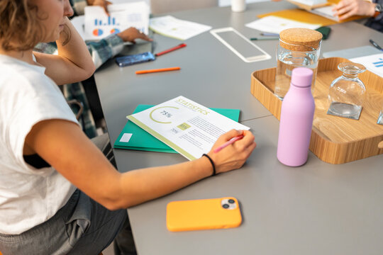 Office coworkers analyzing statistics during business meeting