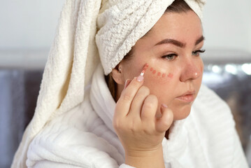 Wman applies makeup on her face