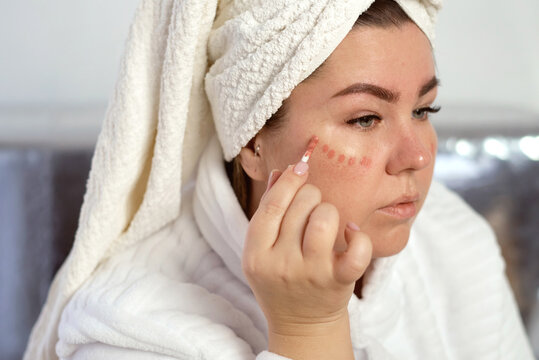 Wman applies makeup on her face