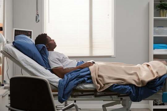 Hospitalized patient resting in bed with nasal cannula and iv drip