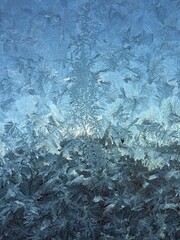 Window frost. Frosted window with ice patterns in winter season. Frozen window. Cold weather.