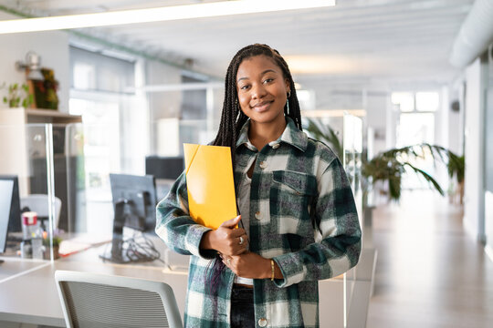 Young manager holding folder smiling in coworking office