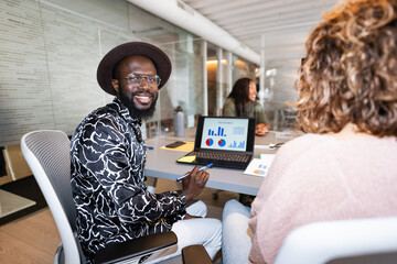 Smiling businessman working with laptop showing charts