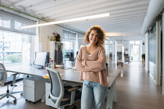 Confident businesswoman smiling in modern coworking space
