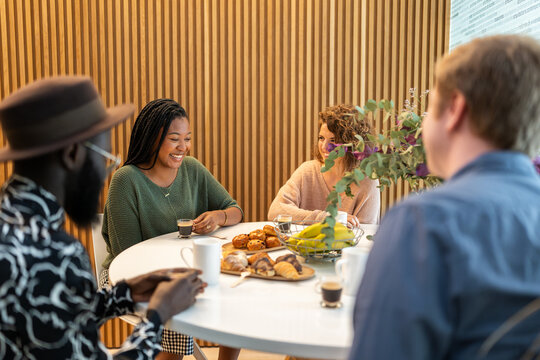 Coworkers enjoying break with coffee and pastries
