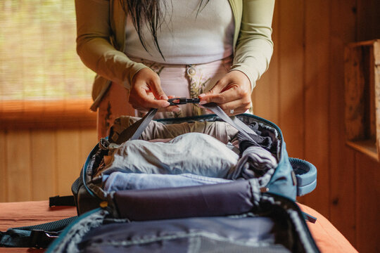 Travel Woman Hands Packing Clothes in Backpack