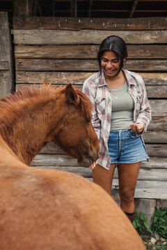 Latina woman with horse at ranch