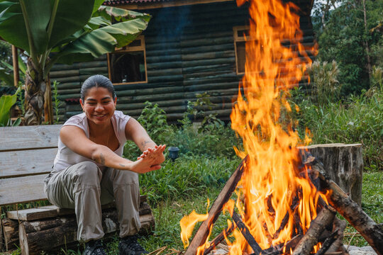 Woman getting warm with a campfire in the forest