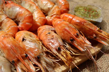 Side View. grilled shrimp on a wooden plate and side dish Seafood dipping sauce. Types of grilled seafood