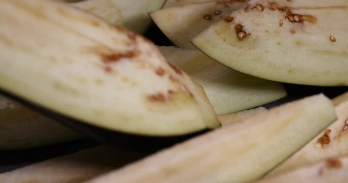 cut lengthwise one eggplant during cooking, the flesh and seeds of sliced ripe eggplant close up