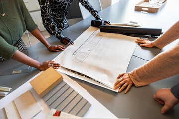 Architects analyzing blueprints and materials in coworking office