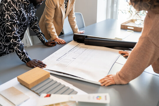 Architects analyzing blueprints and material samples