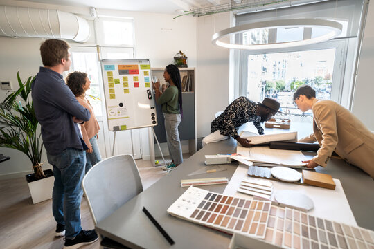 Architects analyzing blueprints and color swatches during a meeting