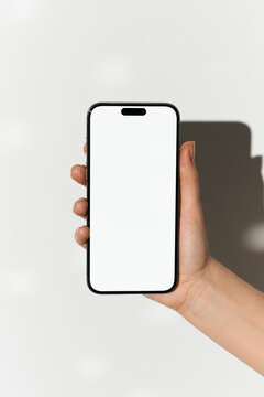Hand holding a mobile phone with white screen