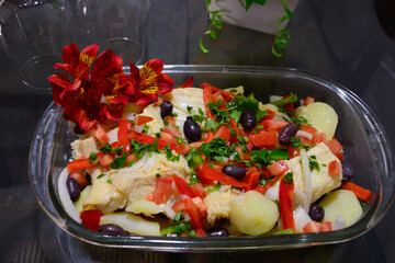 Traditional Portuguese dish Bacalhoada with salted cod, potatoes, olives, and vegetables, served in a rustic plate. Rich in flavor and cultural heritage.