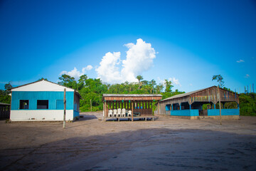 Traditional Amazonian structures with blue accents under a clear sky, Santar&eacute;m.