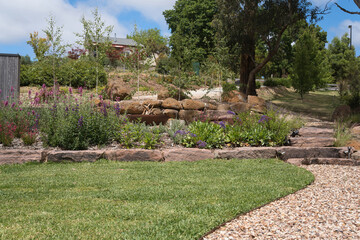 Lush garden landscape with stone pathways and vibrant flora