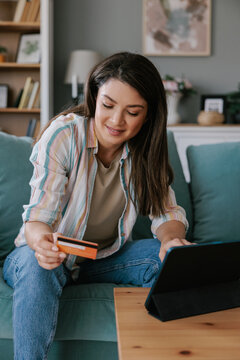 Young Woman Shopping Online With Credit Card on Tablet At Home