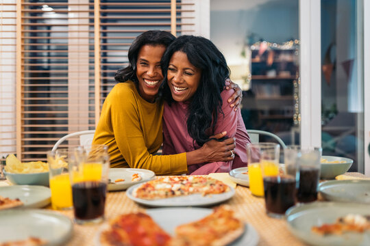 Two women sharing a heartfelt hug at celebration