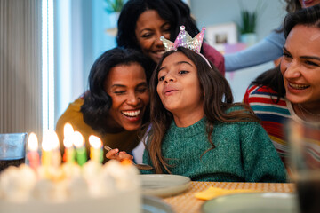 Young girl smiling with friends at birthday celebration