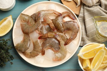 Fresh raw shrimps, ice cubes and spices on light blue wooden table, flat lay