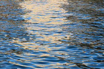 abstract nature background, water surface with waves at sunset