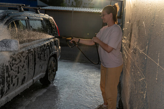 Woman Washing Car with Pressure Washer
