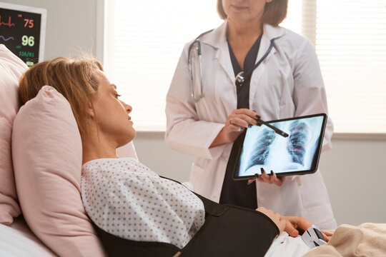 Doctor showing lung radiography to hospitalized patient