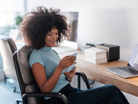 Smiling Woman Using Phone at Office Desk 