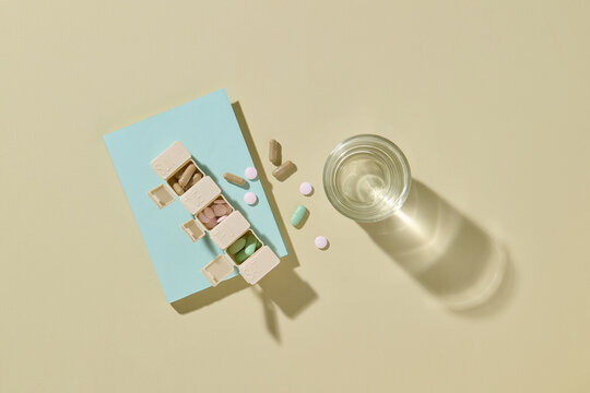 Daily Medication Organizer with Pills and Glass of Water