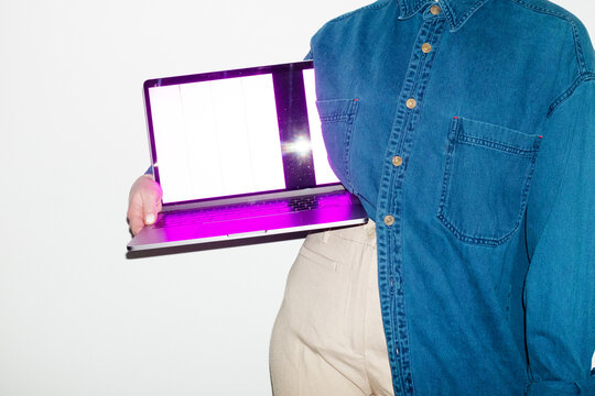 Person holding a laptop with broken screen in office workplace