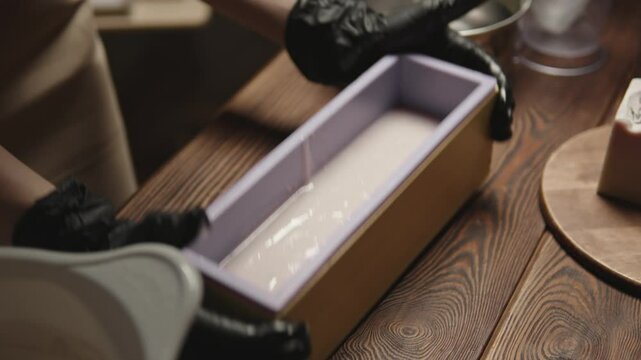 Production of handmade soap from natural oils in a silicone mold. Putting soap raw materials into a mold