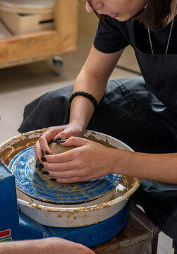 Women's hands working with clay on a potter's wheel