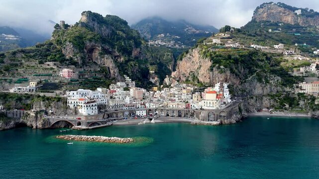Aerial cinematic view of Amali , drone reveal old village with mountains in background dramatic seascape of Italian picturesque town on the Salerno coastline