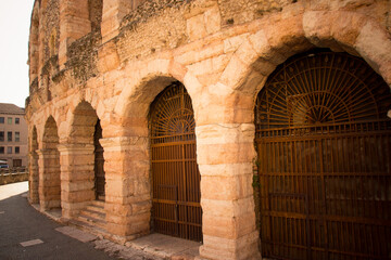 Close-up of the ancient stone archways and iron gates of the Verona Arena, a well-preserved Roman amphitheater in Verona, Italy.