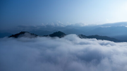 The mountain range with visible silhouettes seen through the colorful fog in the morning.
