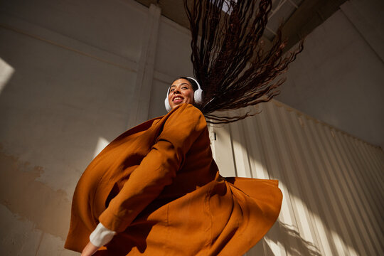 Cheerful woman dancing with flying hair