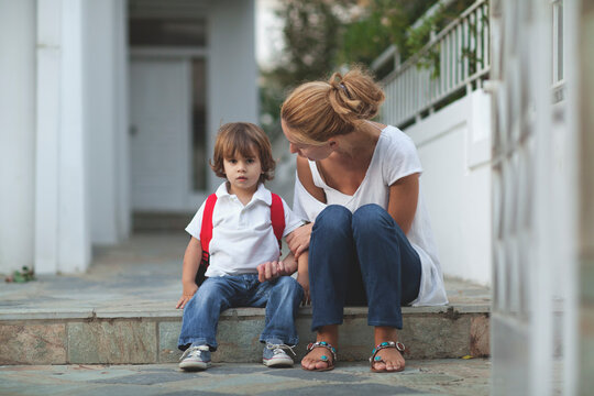 Mother talks to her son before school on a sunny morning