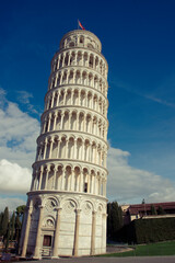 The iconic Leaning Tower of Pisa under a clear blue sky. The tower’s distinct tilt and intricate white marble architecture are prominently featured, symbolizing a historic marvel.
