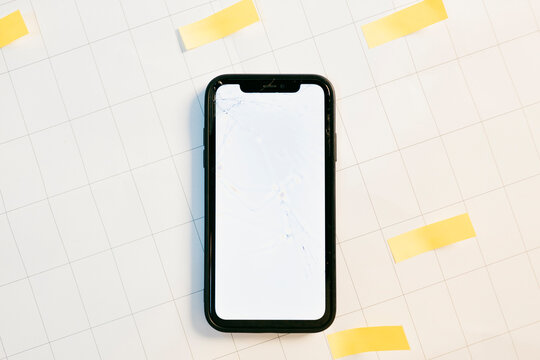 Cell phone with broken screen on paper planning