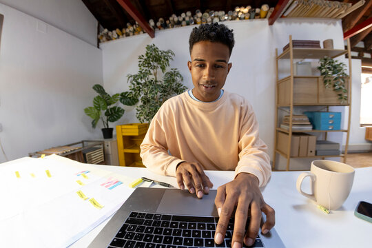 laptop camera POV of young man working in office
