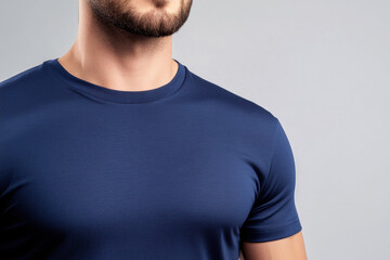 close up of man wearing fitted navy blue t shirt, showcasing modern style and comfortable fit. neutral background emphasizes garment texture and color